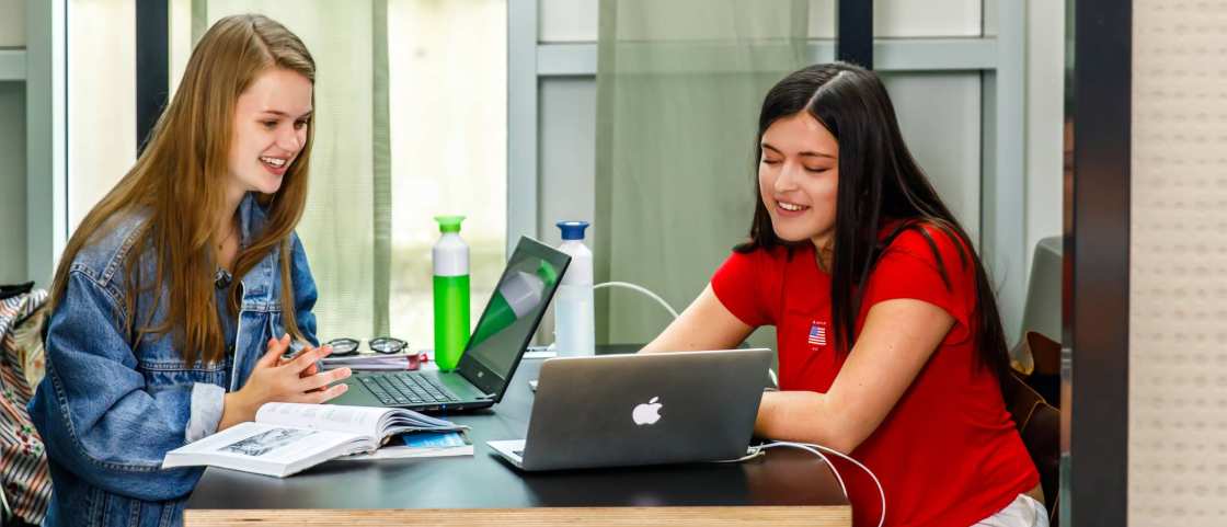 meiden studeren samen met boeken en laptop een meisje rood shirt