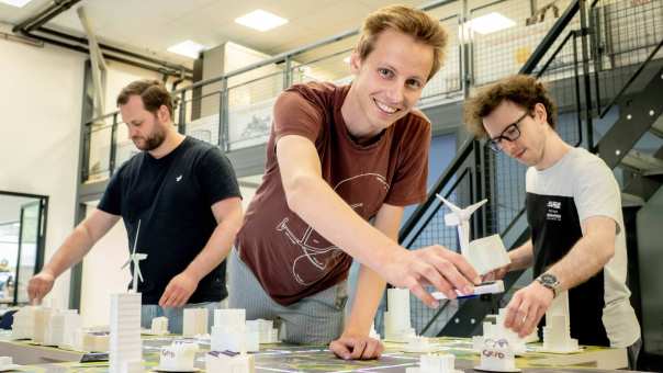 Drie studenten van de masteropleiding Engineering Systems: Sustainable Energy bij de Smart Grid-demotafel.