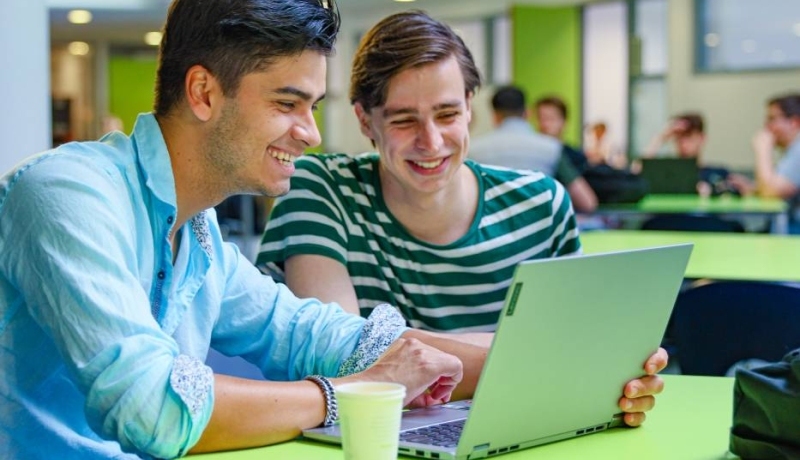 bedrijfskunde voltijd, foto 6817, studenten samenwerken in de kantine, overleg met laptop