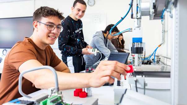 Twee elektrotechniekstudenten werken samen aan een PLC.