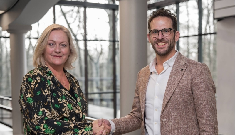 Foto ter ere van de hernieuwde samenwerking tussen de HAN en Business School Nederland. Bart Stolk en Petra van Halteren schudden elkaar de hand.
