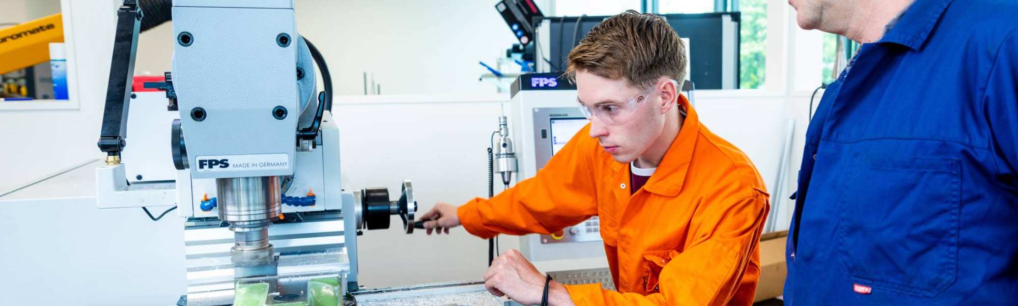 Mechanical Engineering student - Werktuigbouwkunde - with a practical teacher working in the lab