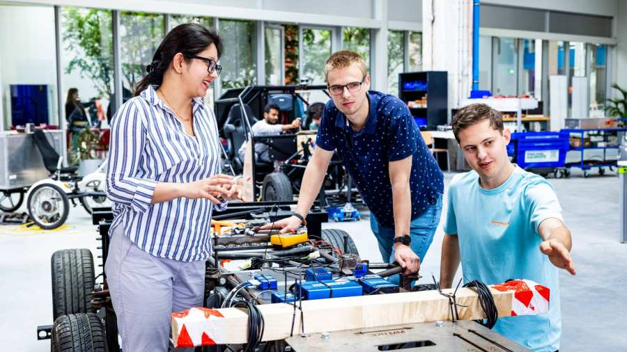 De docent van de Master of Engineering Systems Automotive Systems met twee studenten bij de MORE Vehicle.