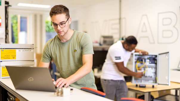 voltijdstudent Mik aan het werk op zijn laptop bij Qirion Alliander