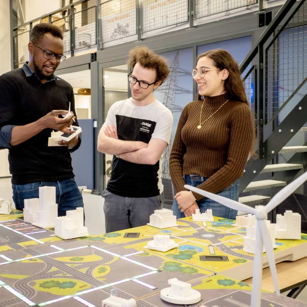 Studenten van de Master Engineering Systems Sustainable Energy en een docent bij de Smart Grid-tafel