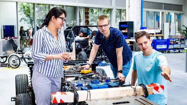 De docent van de Master of Engineering Systems Automotive Systems met twee studenten bij de MORE Vehicle.