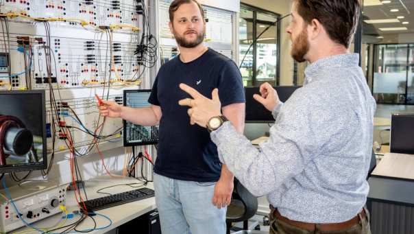 Master Engineering Systems Sustainable Energy student krijgt uitleg van een docent bij de Lucas Nulle panelen.