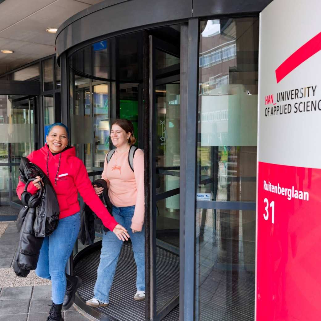 Noa and Chadionne walking through the entrance by Ruitenberglaan 31 HAN Arnhem campus.