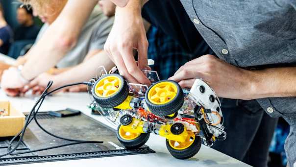 Student Marlo van embedded systems engineering werkt aan een programmeerbare auto.