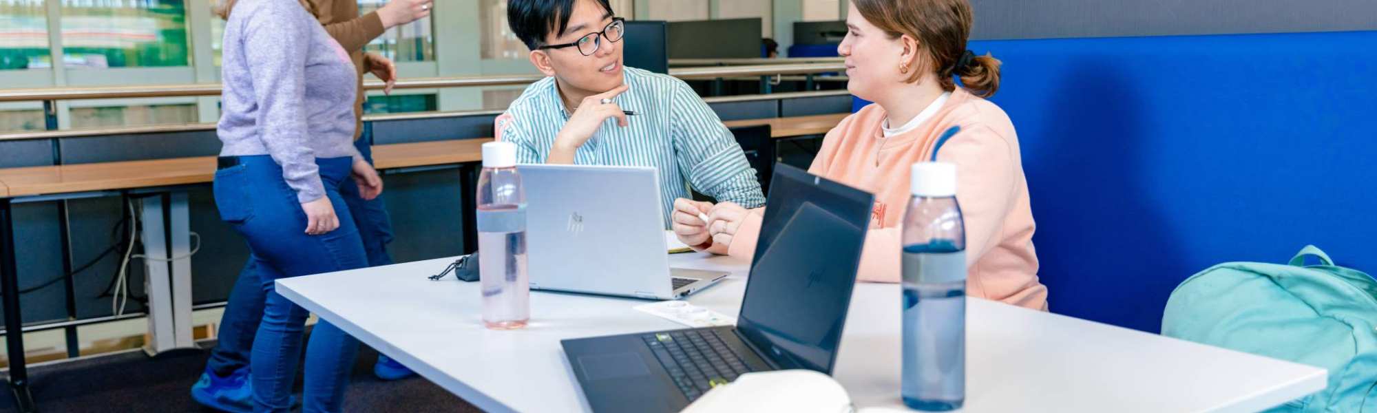 International students Nyugen and Noa studying together in the library on the Arnhem campus of HAN University of Applied Sciences.