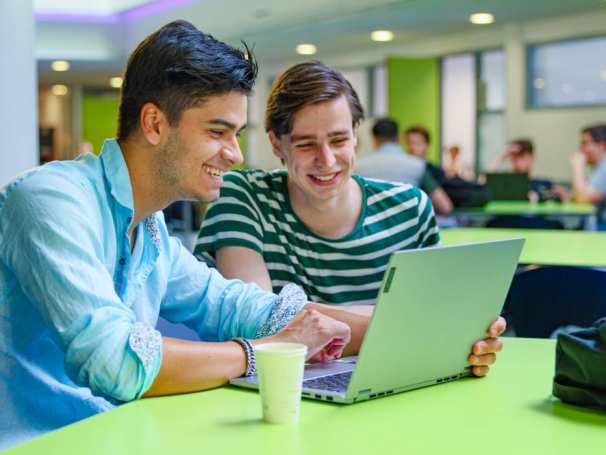 bedrijfskunde voltijd, foto 6817, studenten samenwerken in de kantine, overleg met laptop