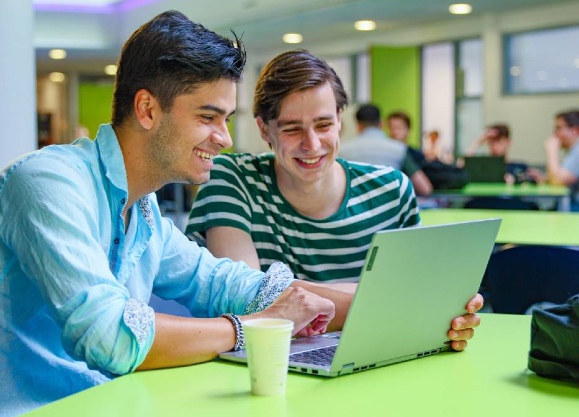 bedrijfskunde voltijd, foto 6817, studenten samenwerken in de kantine, overleg met laptop