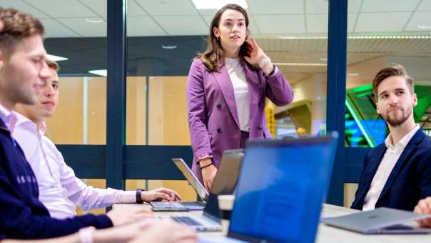 Deeltijd studenten Commerciële Economie werken samen aan sales opdracht op laptop. 