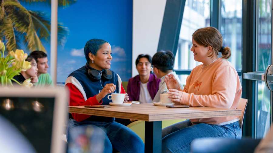 Students Noa, Chadionne, Tam, Diego, Nyugen and Andrei relaxing and drinking coffee in the Hangar on the Arnhem campus of HAN University of Applied Sciences.