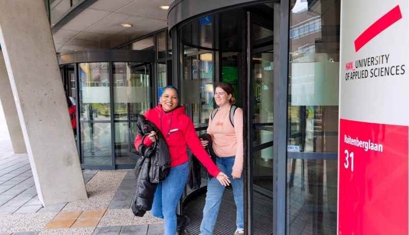 Noa and Chadionne walking through the entrance by Ruitenberglaan 31 HAN Arnhem campus.
