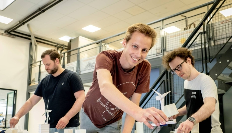 Drie studenten van de masteropleiding Engineering Systems: Sustainable Energy bij de Smart Grid-demotafel.