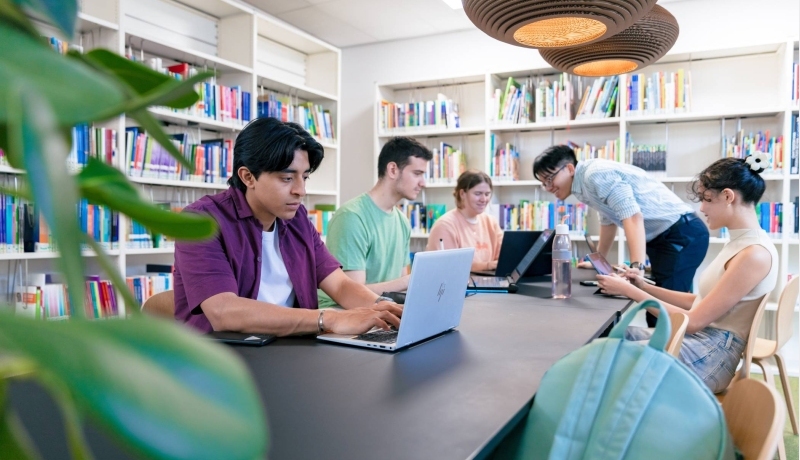 International students Diego, Tam, Nyugen, Noa and Andrei studying in the library at the Arnhem campus of HAN University of Applied Sciences.