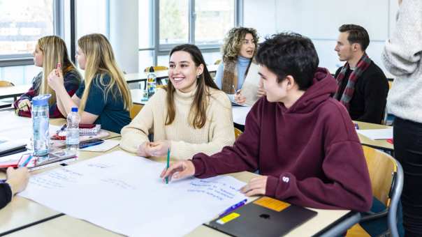 International Social Work. Studenten in collegebanken met praatplaat op tafel