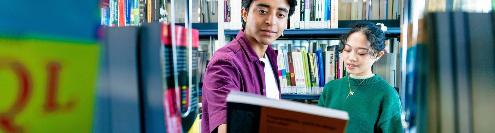 International students Diego and Tam looking for books in the library on the Arnhem campus of HAN University of Applied Sciences.