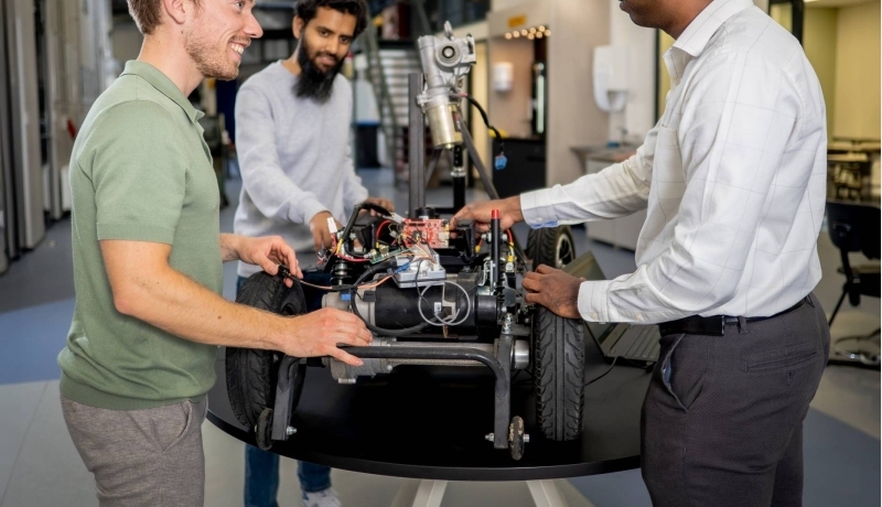 Een docent en twee studenten van de Master Engineering Systems Cyber Physical Systems werken aan het MORE-project, de scootmobiel.