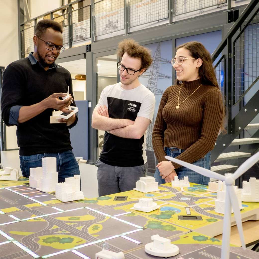 Studenten van de Master Engineering Systems Sustainable Energy en een docent bij de Smart Grid-tafel