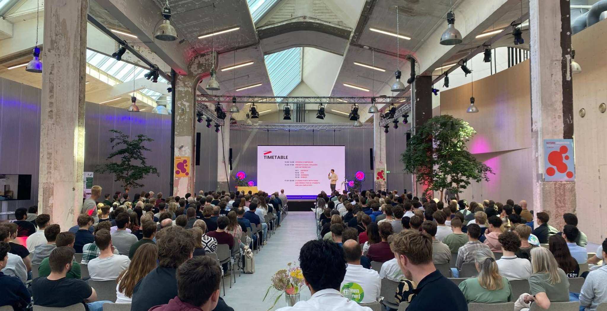 Sfeerbeeld van een volle zaal tijdens start van symposium Beyond met keynote sprekers en presentatie van semester 6 projecten door de studenten zelf. Locatie: Connectr op IPKW-terrein in Arnhem.