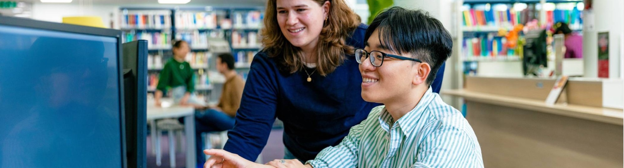 Two master students in Applied Data Science working behind a computer.