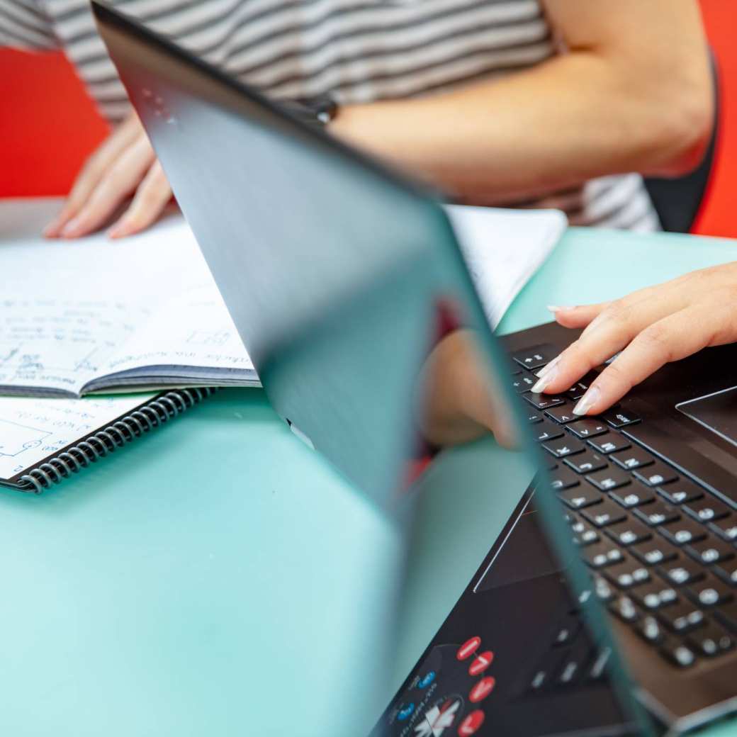 Detailfoto studenten met laptop en aantekeningen