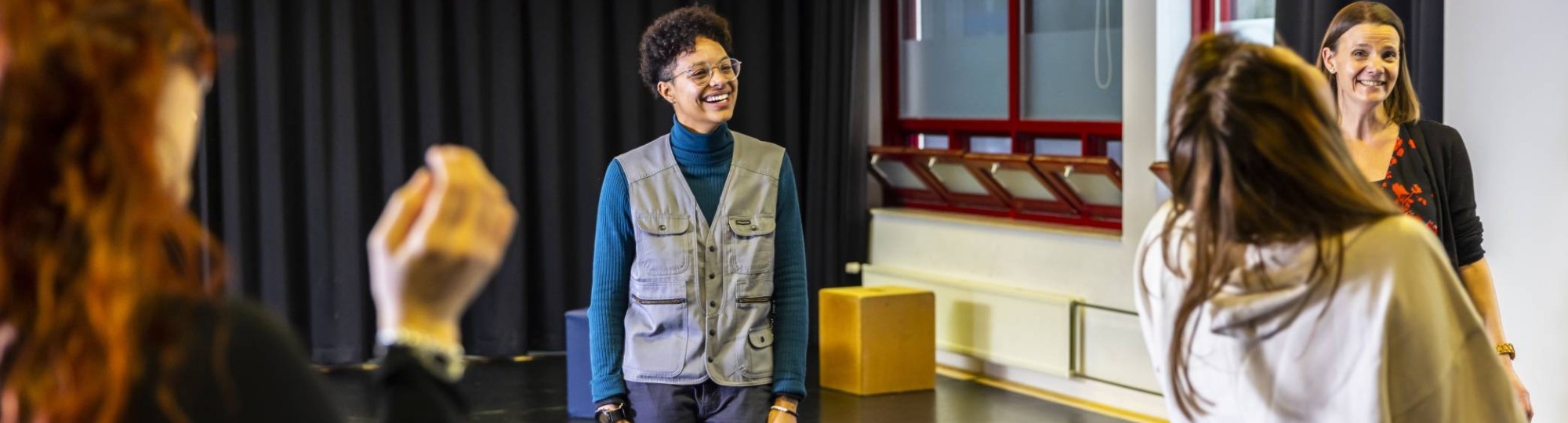 Studenten international social work in drama lokaal. In het midden een student met zwarte krullen en een grijze bodywarmer.