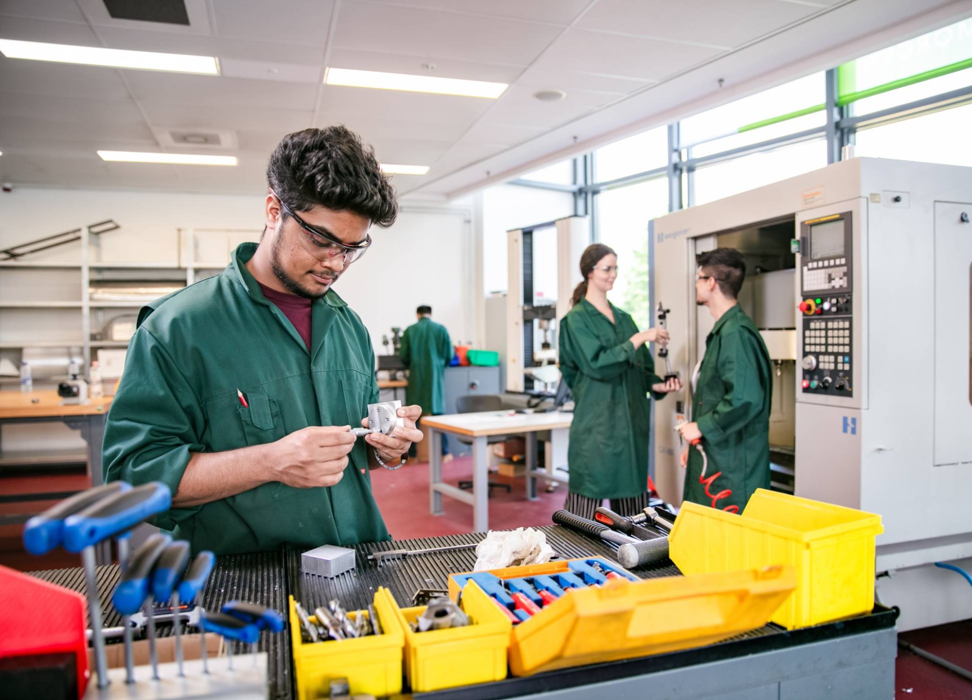 bij werkbank met CNC-machine op achtergrond