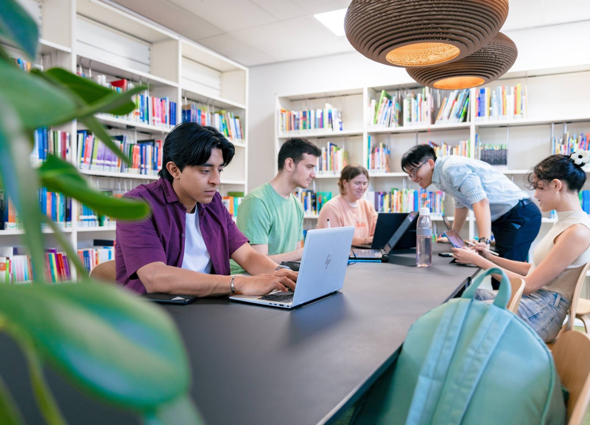 International students Diego, Tam, Nyugen, Noa and Andrei studying in the library at the Arnhem campus of HAN University of Applied Sciences.