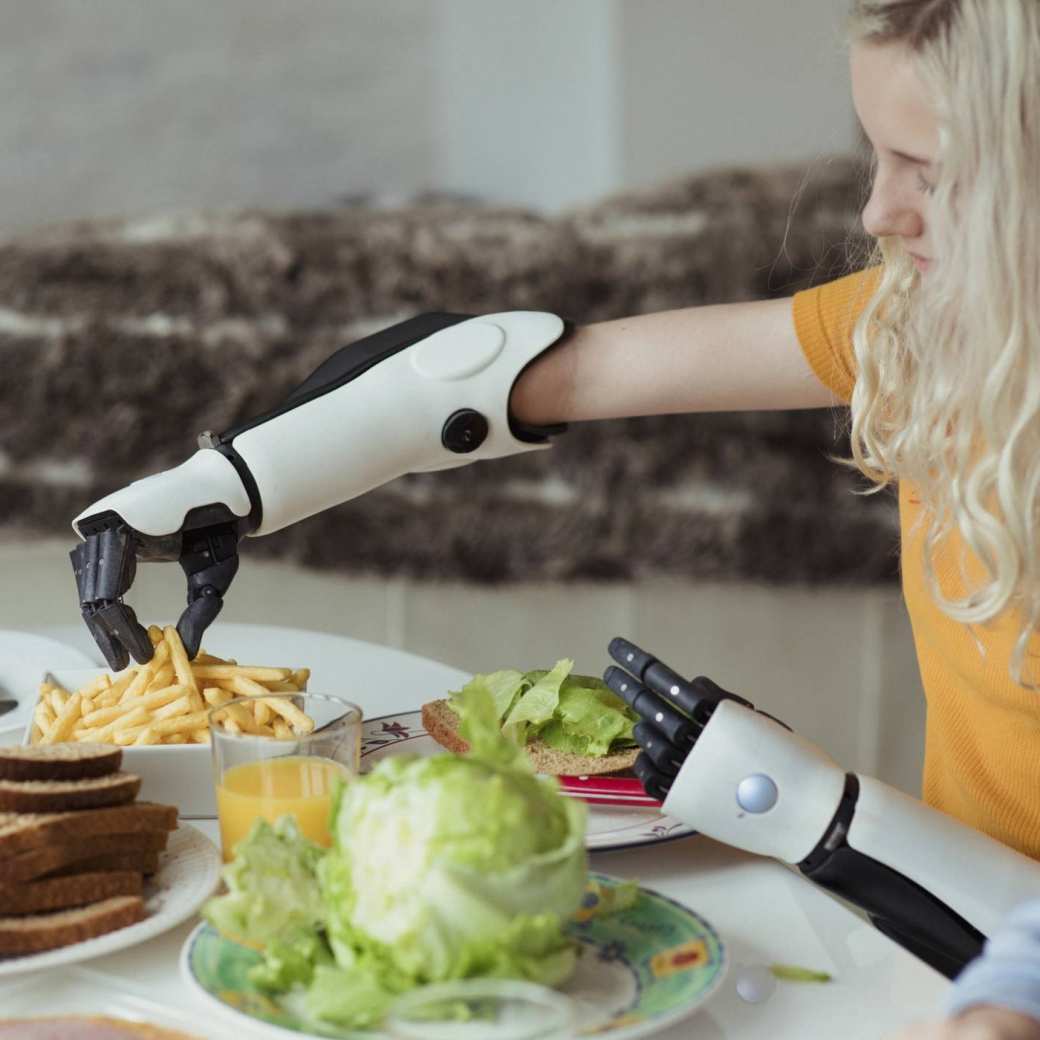 met prothese armen neemt frietjes aan tafel met goep tienermeisje