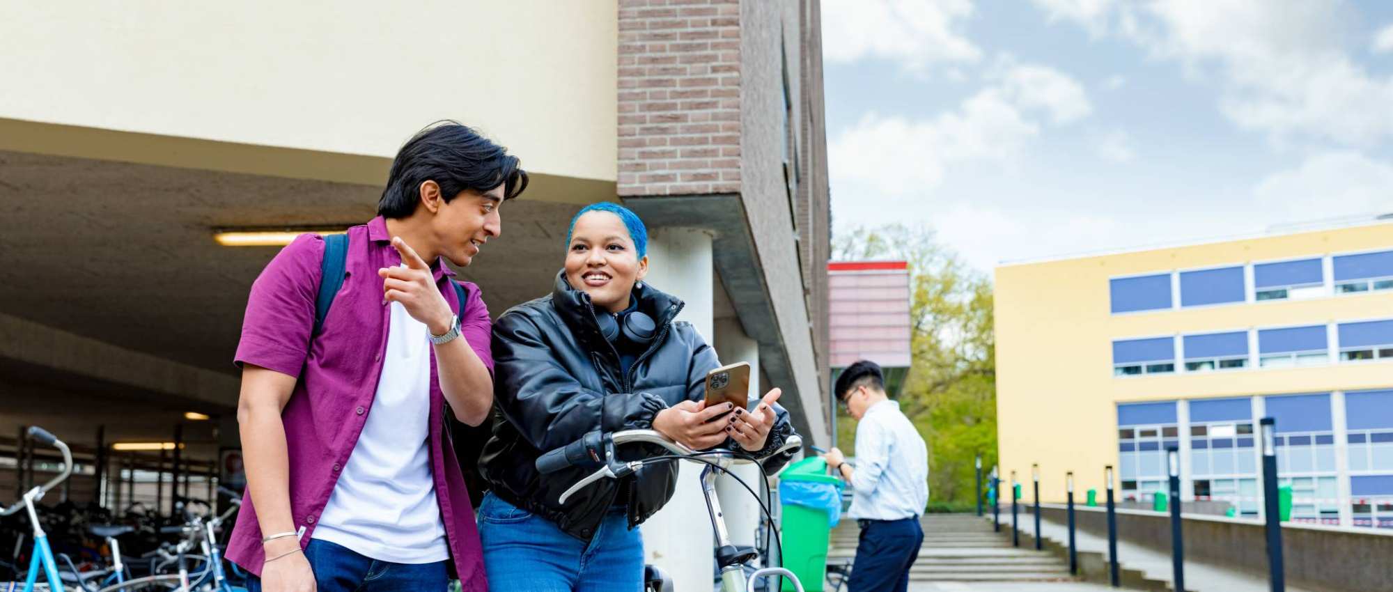 International students Diego and Chadionne with their bikes looking for directions on the Arnhem campus of HAN University of Applied Sciences.