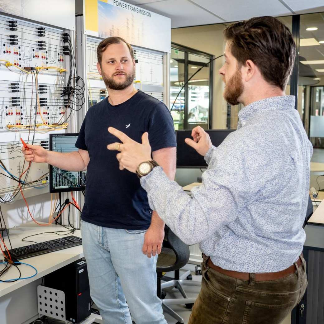 Master Engineering Systems Sustainable Energy student krijgt uitleg van een docent bij de Lucas Nulle panelen.