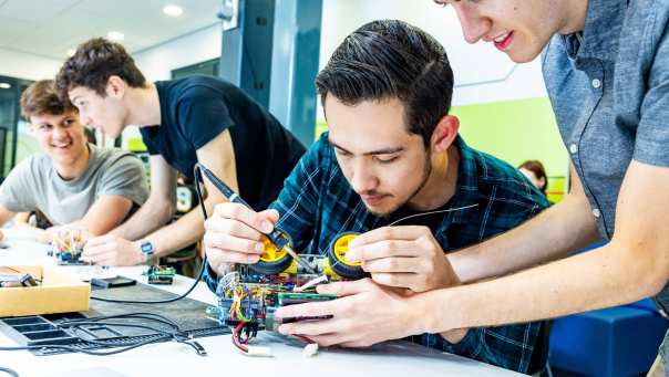 Studenten embedded systems engineering solderen aan programmeerbare auto.