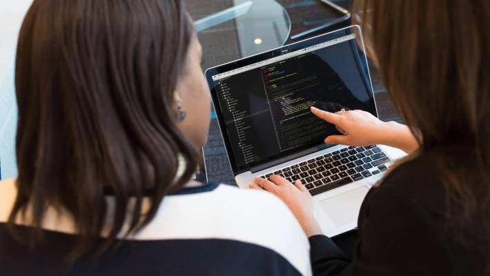 Two students in Bioinformatics working with a laptop.