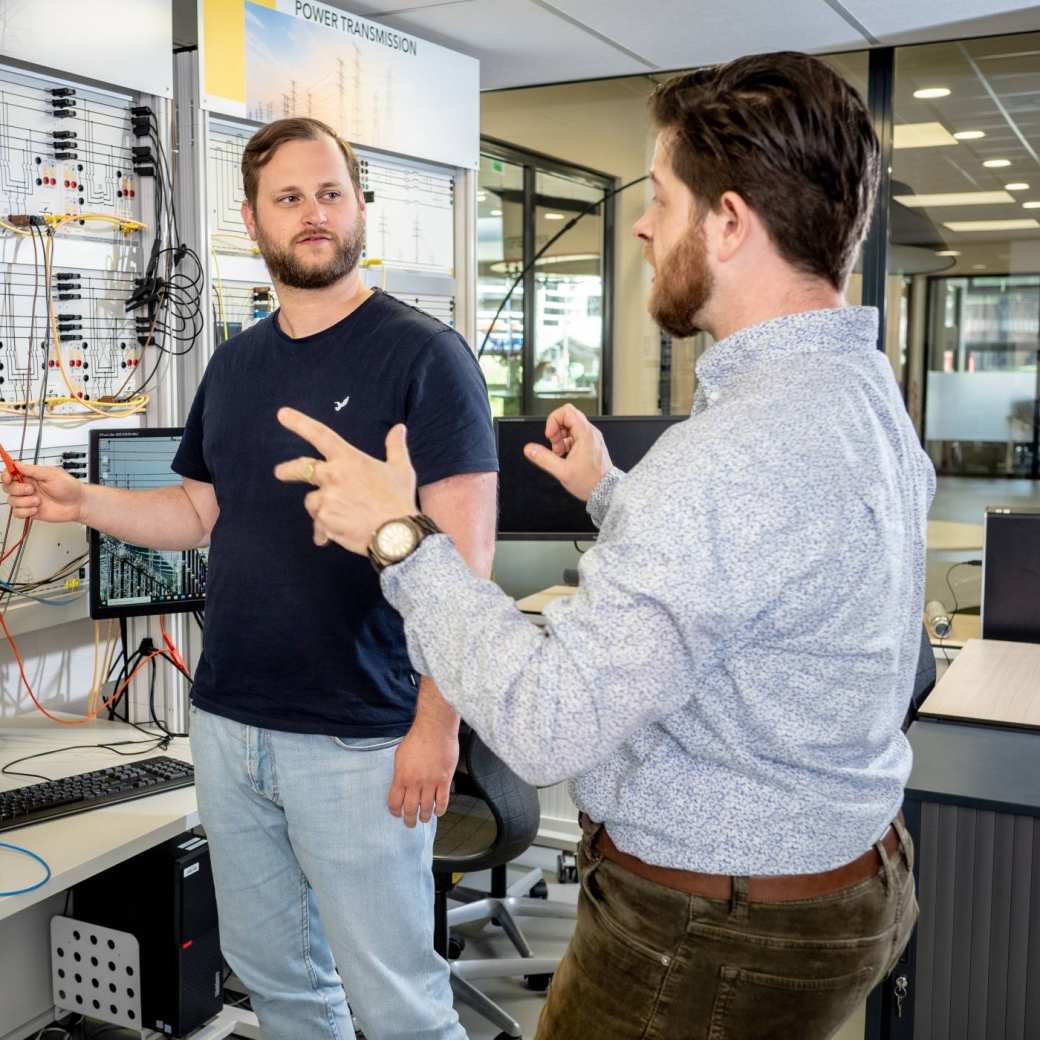 Master Engineering Systems Sustainable Energy student krijgt uitleg van een docent bij de Lucas Nulle panelen.