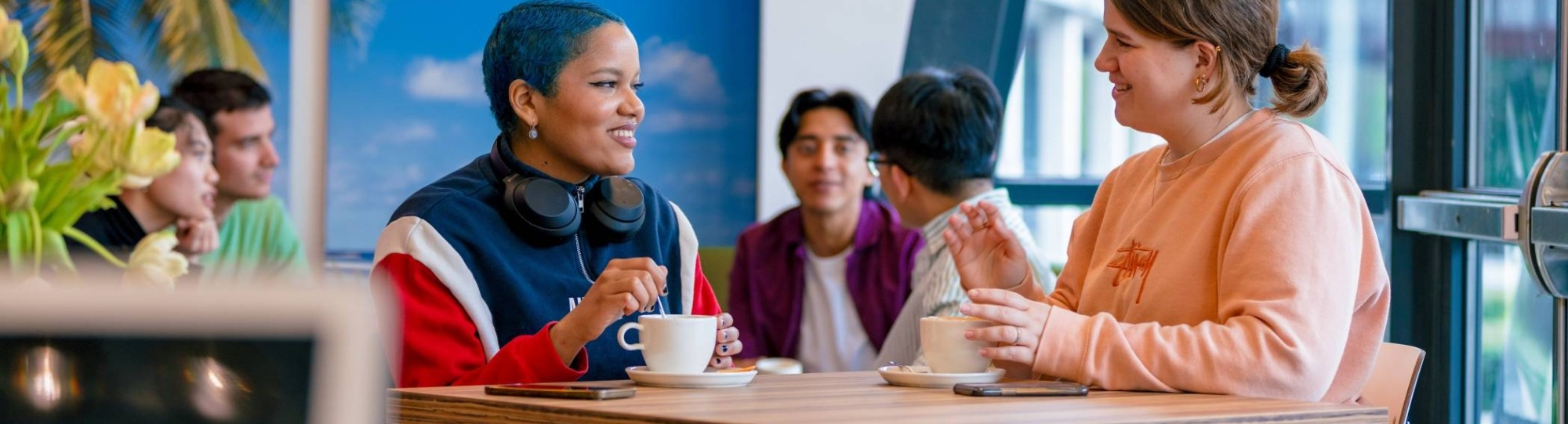 Students Noa, Chadionne, Tam, Diego, Nyugen and Andrei relaxing and drinking coffee in the Hangar on the Arnhem campus of HAN University of Applied Sciences.