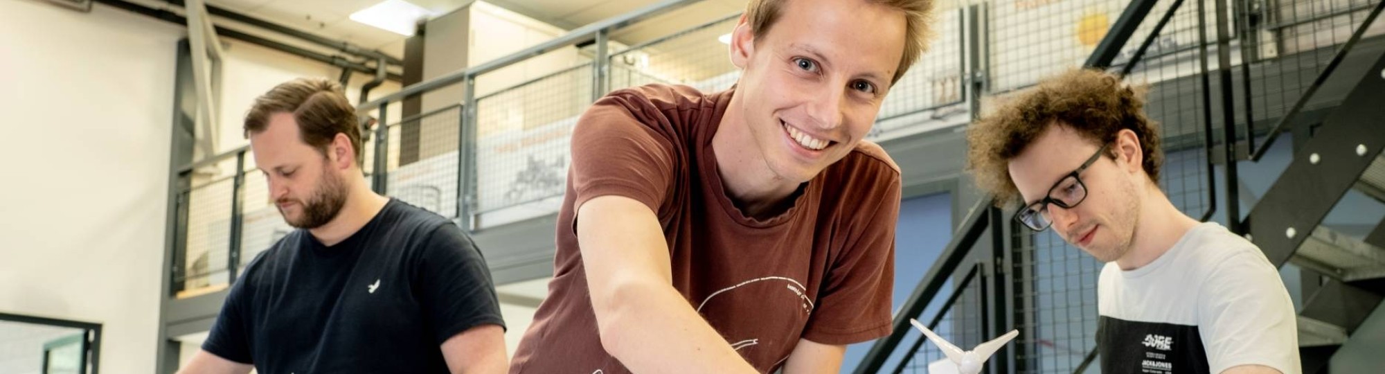 Drie studenten van de masteropleiding Engineering Systems: Sustainable Energy bij de Smart Grid-demotafel.