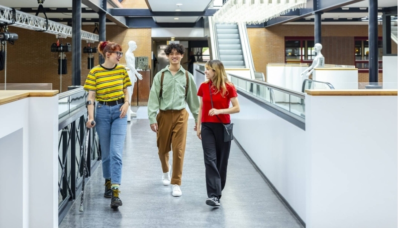 Studenten lopen door gang. Campagne studiejaar 23-24. Student Support Center. Fotoshoot 2023.