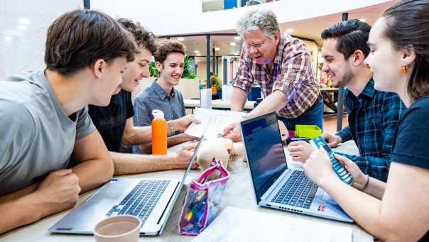 Een docent geeft uitleg aan studenten van de opleiding embedded systems engineering op het health concept lab.